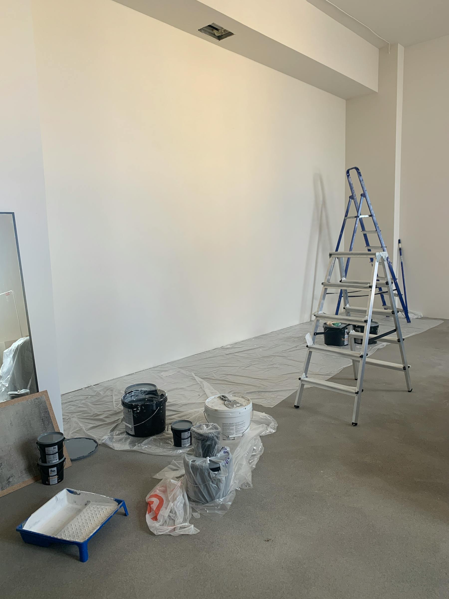 Pièce intérieure protégée avec matériel de peinture et escabeau
